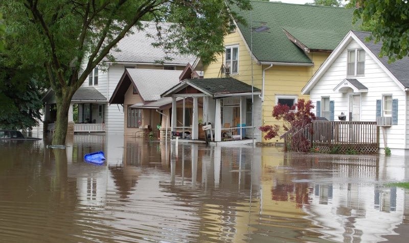 Flood waters up to the porches of older homes lining street in Iowa